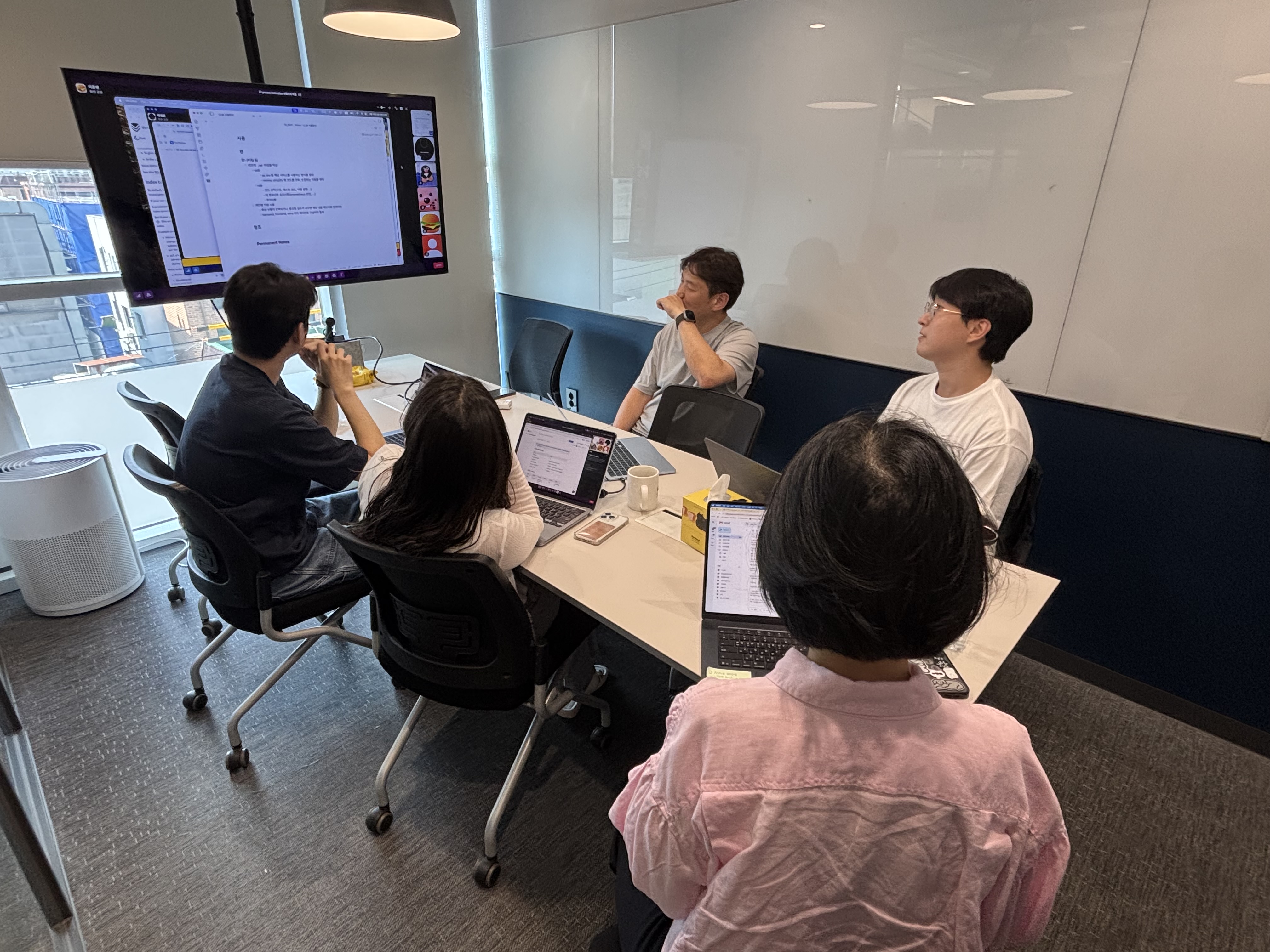AI 도구 도입 3개월 후, 주식회사 텐 CPO 조직 구성원들이 회의실에서 노트북과 화면을 보며 개발·기획 업무 변화에 대해 논의하는 모습.